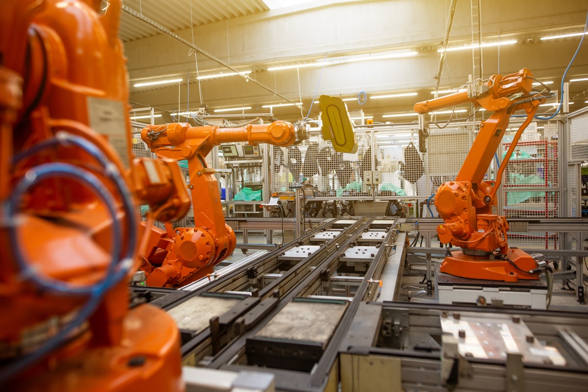 Orangefarbene Industrieroboter an einer automatisierten Fertigungslinie