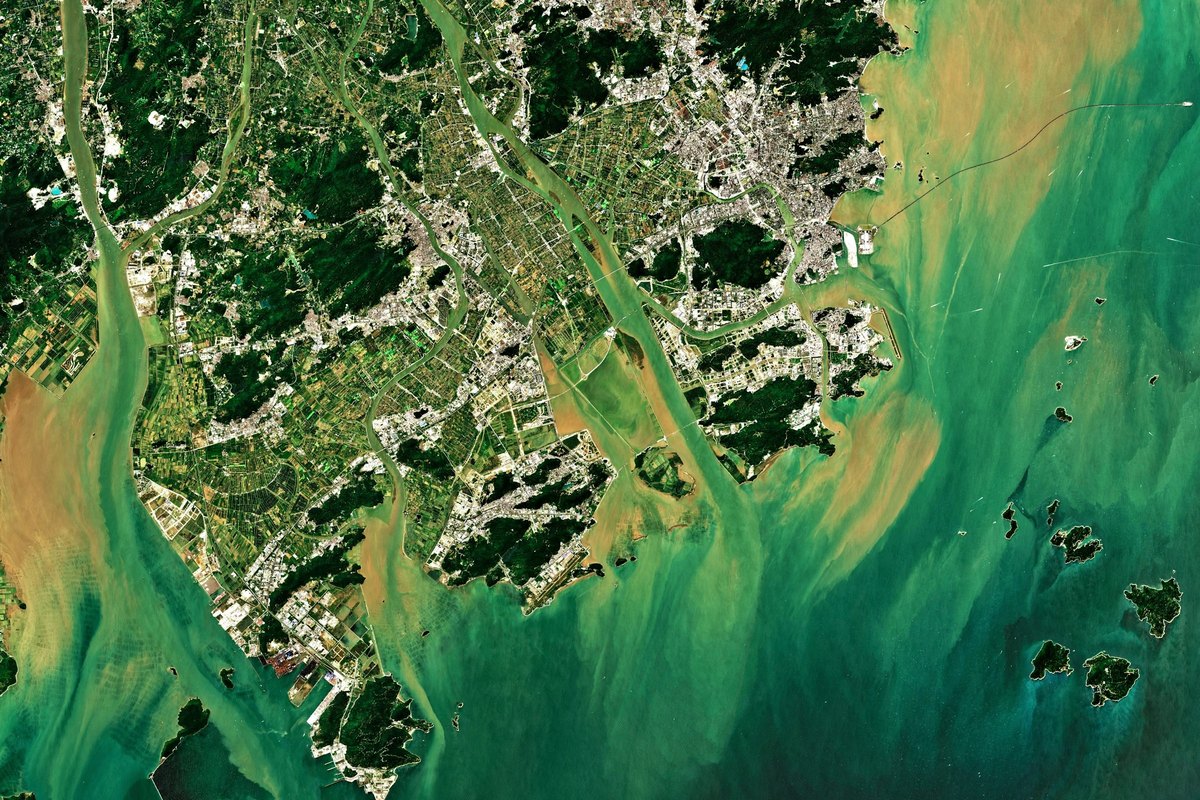 Satellitenaufnahme einer Küstenregion mit Siedlungs-, Vegetations- und Wasserflächen