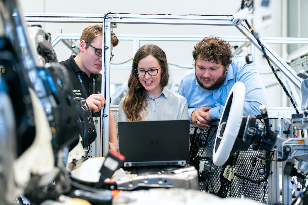 Drei Ingenieure prüfen Fahrzeugsoftware an einem Prüfaufbau